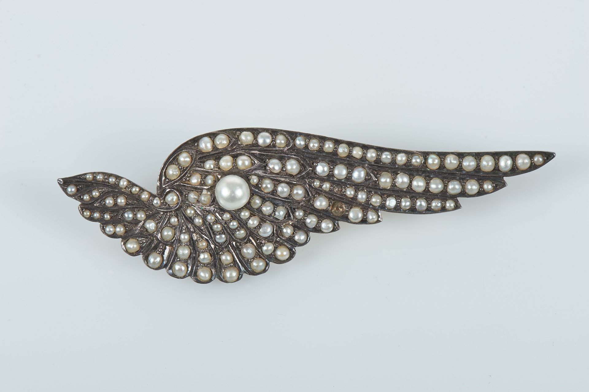 A Brooch "Wing", gold and silver, set with 1/2 pearls and 1 natural pearl (4.7mm), European, 19th/