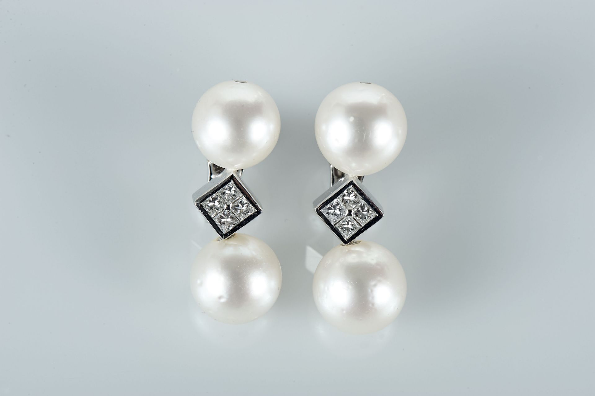 A Pair of Earrings, 800/1000 gold, set with 4 pearls of the South Seas (10.5 mm) and 8 princess