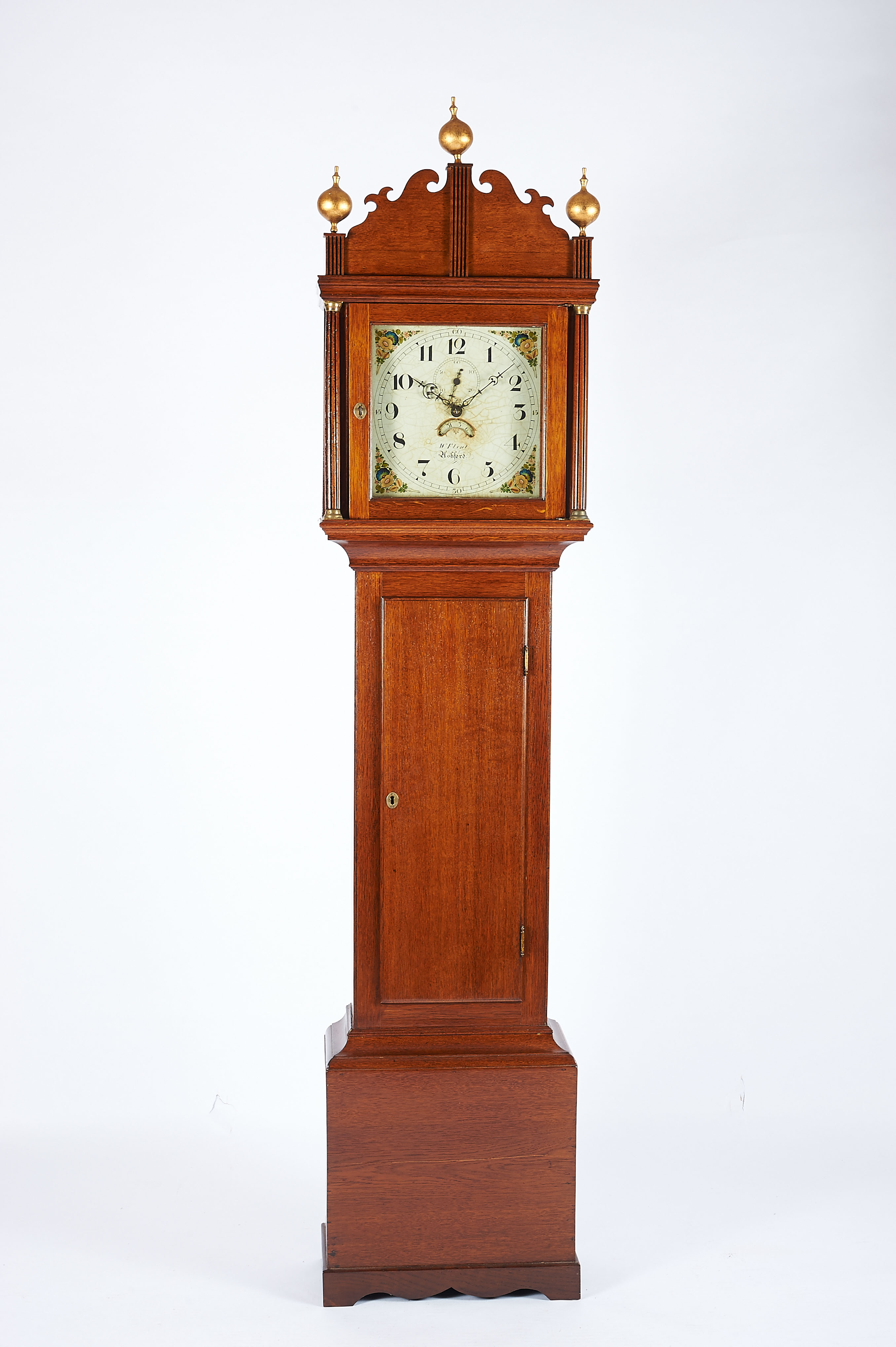 A Longcase Clock, oak case, ribbed columns and friezes with brass applications, painted dial, 30-