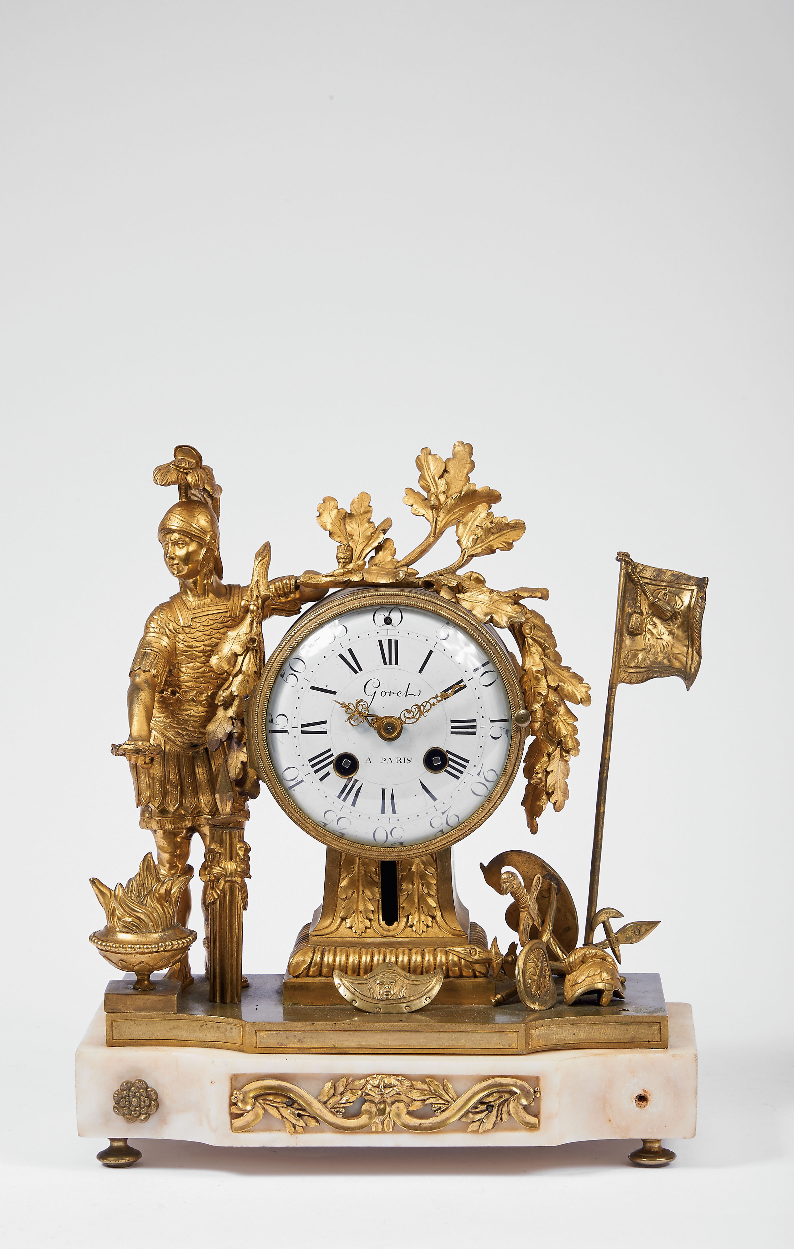 A Table Clock, Louis XVI style, gilt bronze en relief "Mars and his armour", marble stand with