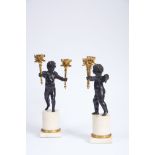 A Pair of Two-light Candelabra, Louis XVI style, patinated and gilt bronze "Putti holding