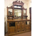 A large late Victorian oak sideboard, raised back incorporating six bevelled mirror plates, break-