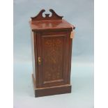 A late Victorian inlaid mahogany bedside cupboard, swan-neck pediment above panelled marquetry door,