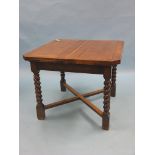 A dark oak draw-leaf dining table, on barley-twist legs and cross-stretchers, 3ft. opening to 6ft.