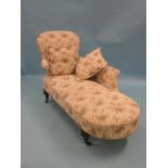 A Victorian chaise longue, upholstered in a machine tapestry, on turned legs with casters