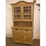 An early 20th century pine kitchen dresser, pair of glazed doors enclosing two shelves, panelled