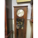 An early 20th century electric longcase clock, with silvered dial, bevelled glass trunk door, with