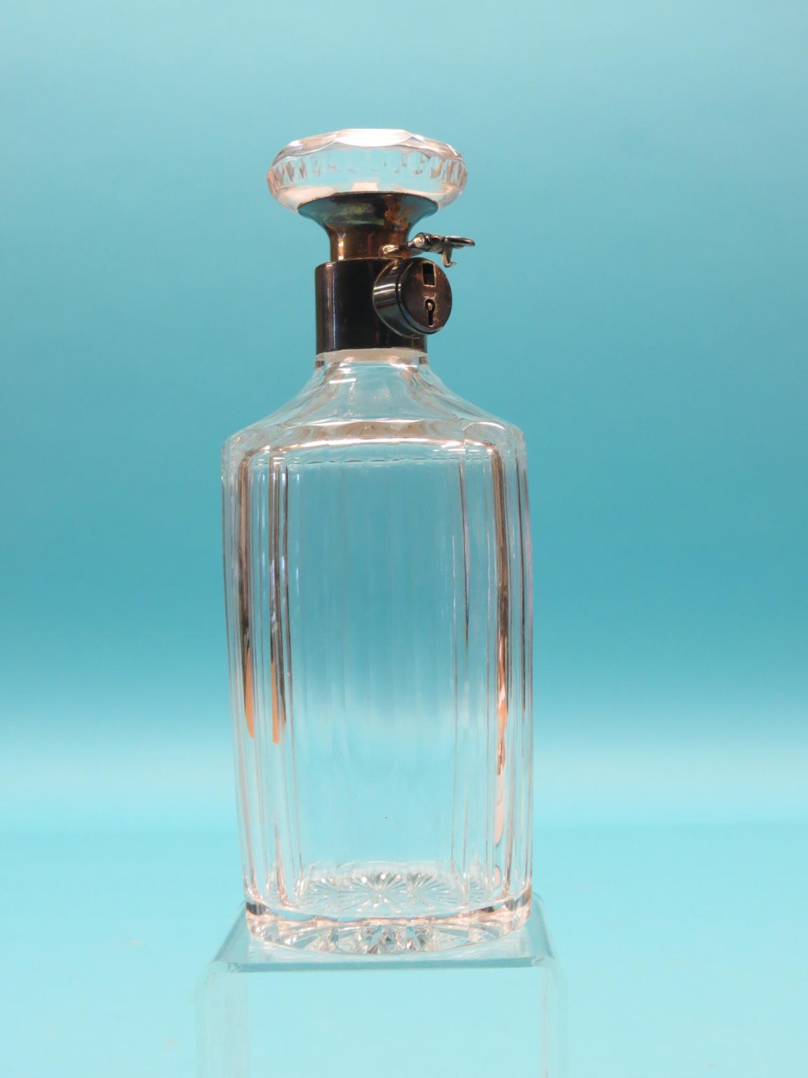 An unusual silver-mounted glass decanter, silver mounts incorporating lock with key, 9.5in.
