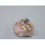 A 9ct. gold ring, step-cut blue stone and diamond-chip shoulders, claw settings, size P