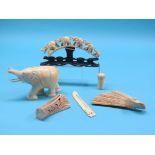 A carved ivory elephant, 6.5in. long, carved ivory herd of five elephants, similar paper knife,