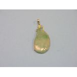 A Chinese jade pendant, with incised leaf carving, on 14ct. gold mount