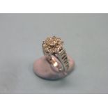 A diamond cluster ring, rosette design of eleven stones, pierced white metal shank, size M/N