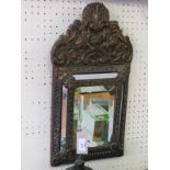 A Spanish brass wall mirror, rectangular-shape with arched cresting, embossed throughout with