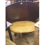 A good reproduction faded mahogany tripod table, oval top on carved supports, 2ft. 4in., together