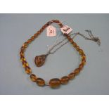 A simulated amber bead necklace, and a reconstituted amber pendant, on chain