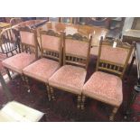 A set of four Victorian walnut dining chairs, carved backs with spindles, upholstered seats and
