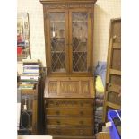 A period-style dark oak bureau bookcase, pair of leaded glass doors enclosing three shelves,