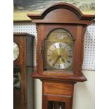 An Emperor Clock Co. grandmother clock, arched dial with moon phases, chiming movement, in fruitwood