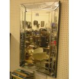 A wrought metal lamp stand, stem with two shelves, and an Art Deco-style frameless mirror with