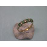 A 9ct. gold half-eternity ring, set four emeralds and diamond chips, size Q