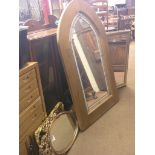 A large arched pine wall mirror, with leaded plate, 4ft. 4in. high, a large dark oak mirror with