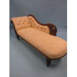 A Victorian chaise longue, mahogany frame carved with leaf-scrolls, on turned legs with casters,