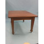 An early 20th century solid oak dining table, with two extra leaves, on square tapering legs with