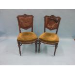 A pair of Victorian mahogany dining chairs, backs deeply-carved with foliage, on front tapering