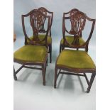 A set of four Hepplewhite-style dark mahogany dining chairs, shield-backs with drop-in green