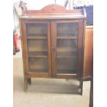An early 20th century dark oak bookcase, two shelves enclosed by a pair of glazed doors, 2ft. 6in.