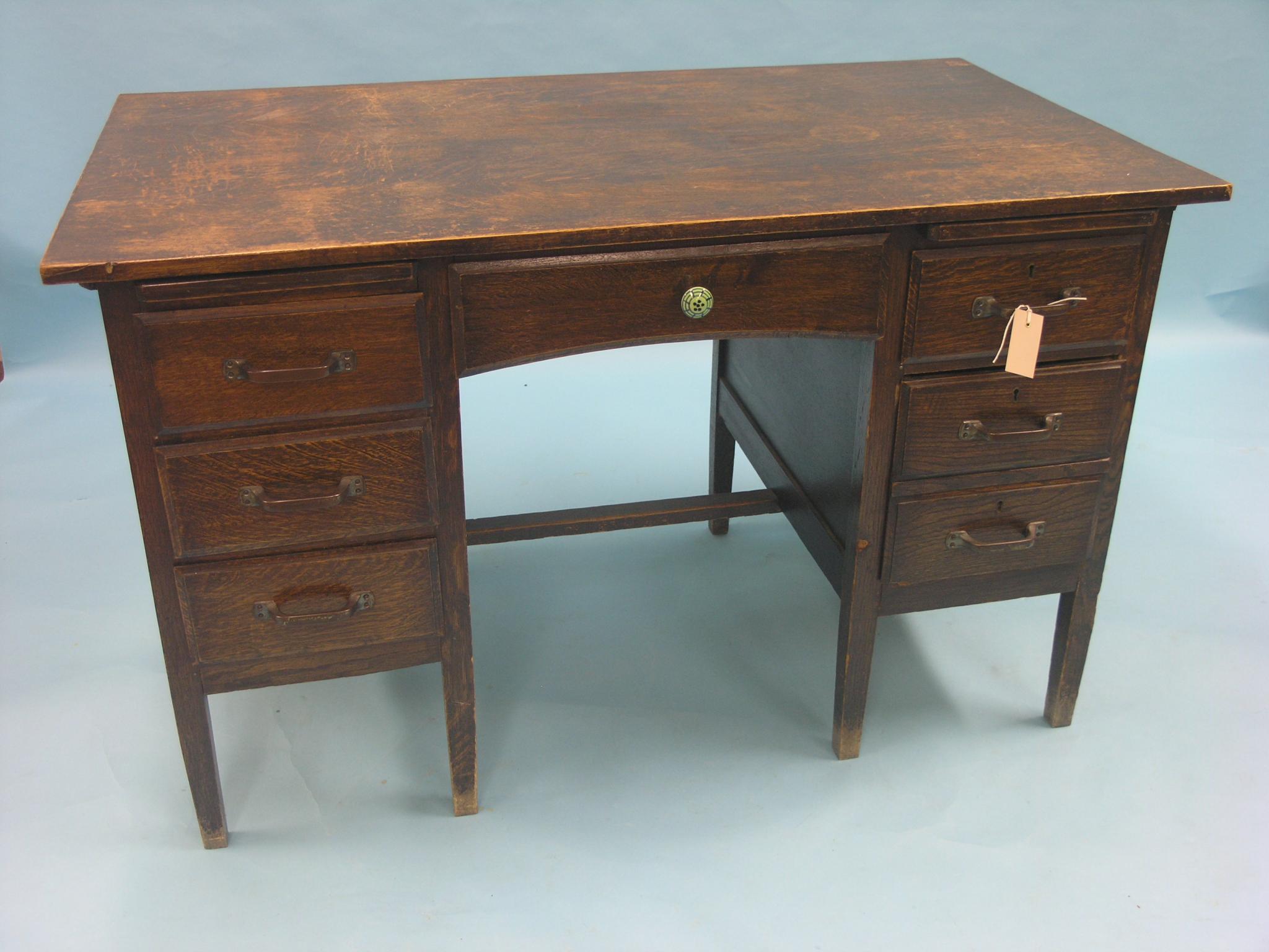 An early 20th century dark oak office desk, kneehole arrangement of six drawers, 4ft. - top marked
