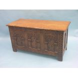 A good Elizabethan-style solid oak coffer, panelled construction with boarded top, frontage carved