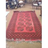 An eastern wool rug, geometric medallion design in crimson and black, 9ft. 6in. x 6ft. 6in.