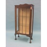 A dark oak display cabinet, bow-fronted single door enclosing two plate glass shelves, claw and ball
