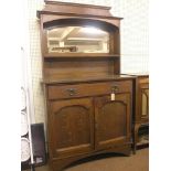 An Art Nouveau solid oak sideboard, raised back with bevelled mirror, panelled cupboard base with