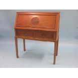 An Eastern hardwood bureau, fall-front with carved medallion, enclosed fittings above two drawers,