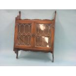 An oak wall-hanging bookcase, enclosed by a pair of leaded, glazed doors, 2ft. 10in.