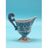 An 18th century Dutch Delft ewer, fluted pedestal form with scroll handle, painted with foliage in