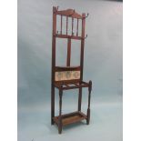 A Victorian mahogany hall stand, fitted with iron coat-hooks, printed ceramic tiles and umbrella
