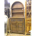 A Reprodux dark oak canopy dresser, with two fitted over-shelves, panelled cupboard base with single