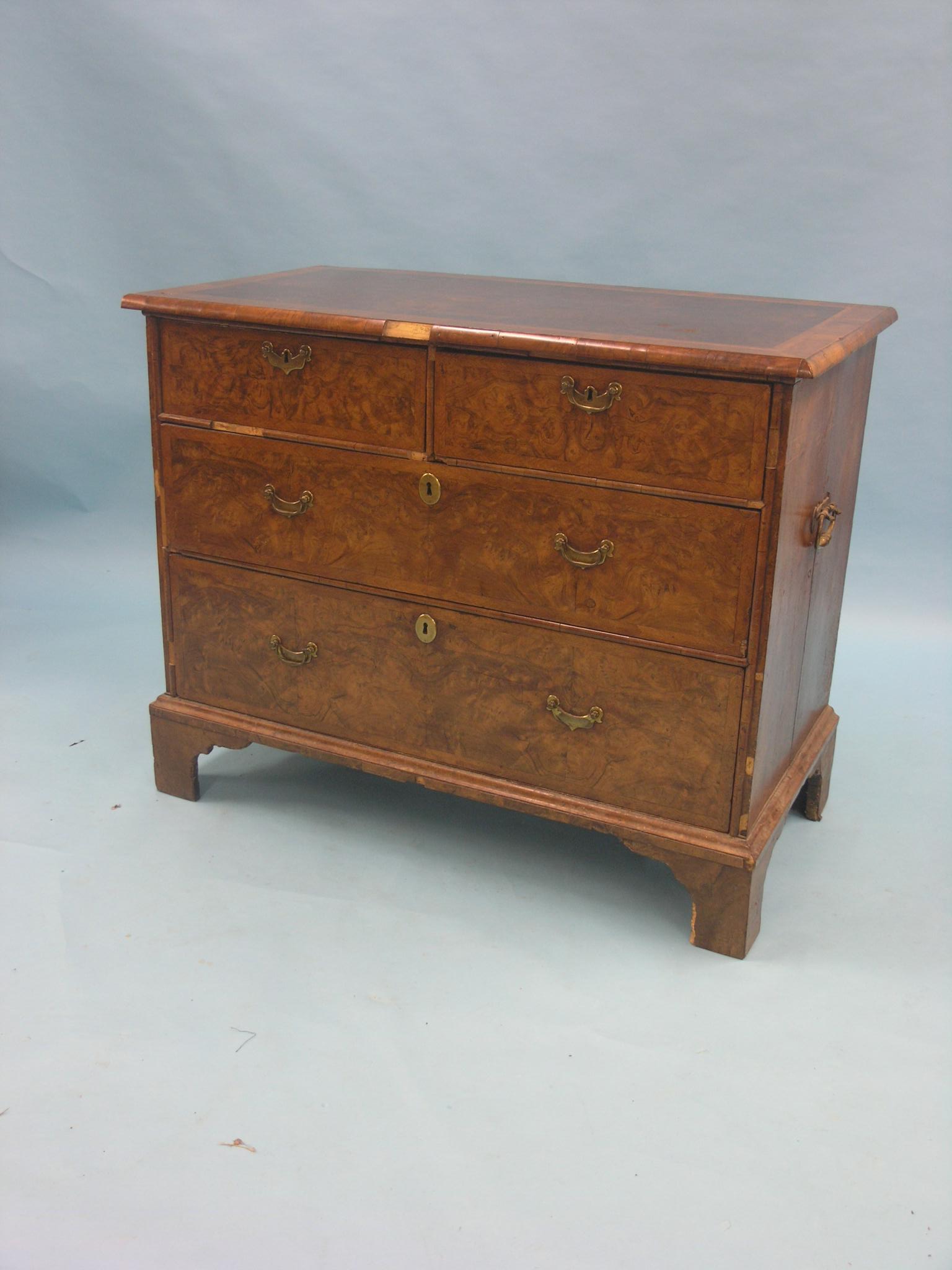 An early Georgian burr walnut chest, quarter-veneered and cross-banded top with herringbone inlay,