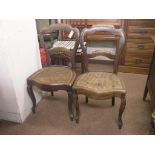 A pair of Victorian solid rosewood balloon-back dining chairs, with caned seats, on front cabriole