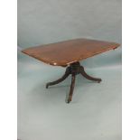 An early 19th century mahogany tilt-top dining table, rectangular top with broad rosewood cross