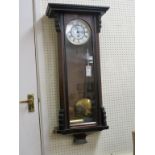 A 19th century Vienna-type wall clock, with enamelled dial, in ebonised walnut case, with a key,