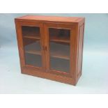 An Eastern hardwood bookcase, pair of glazed doors enclosing two shelves, 2ft. 10in.