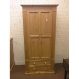A solid, waxed pine wardrobe, panelled door enclosing space for hanging, two drawers beneath, 2ft.