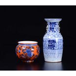 An orange-ground porcelain jardinière and a blue and white vase, China, Qing [...]