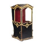 A sedan chair in black leather with profiles and decors in carved and gilded wood, [...]