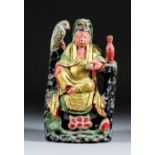 A Chinese carved polychrome and giltwood seated figure of Guanyin Pusa holding a scroll in her