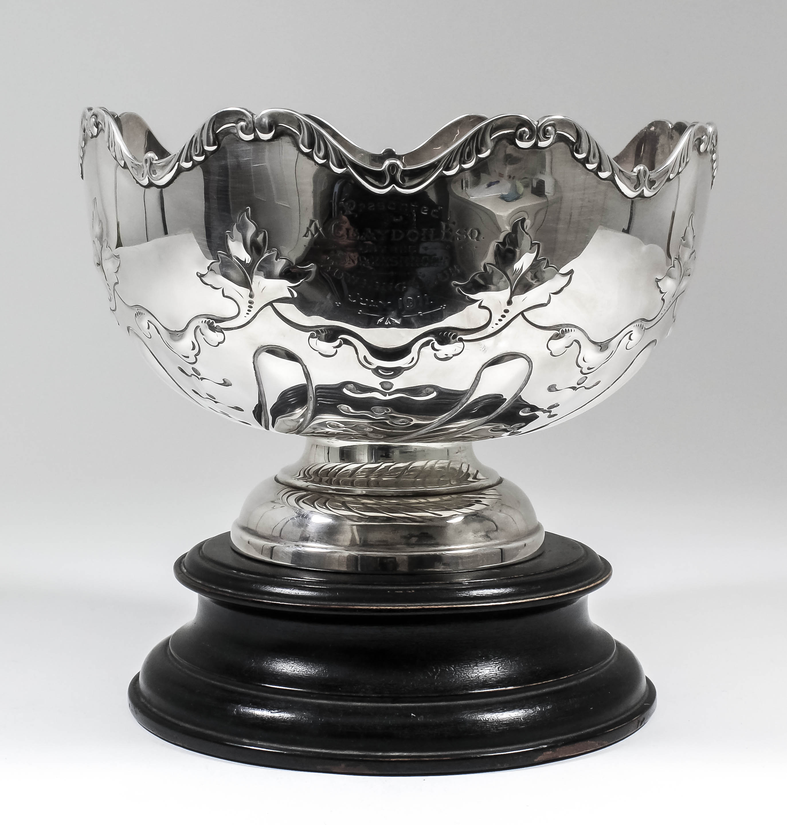 A George V silver circular rose bowl, the shaped rim cast with scroll ornament, the body embossed